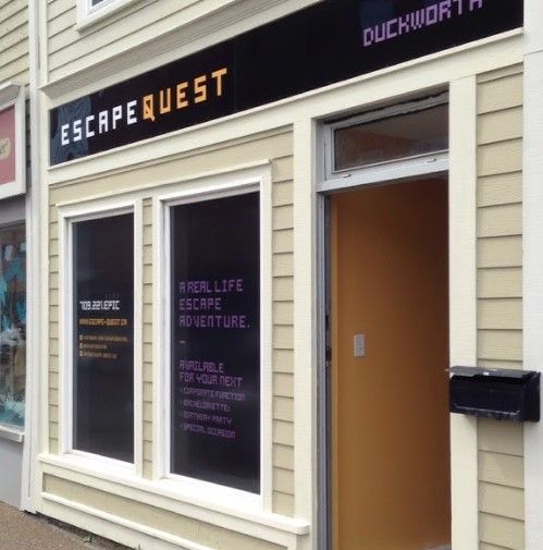 Exterior of Escape Quest, an escape room business, with sign and open door.