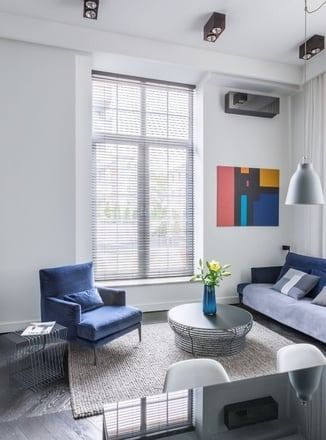 A living room with a couch , chair , coffee table and large window.