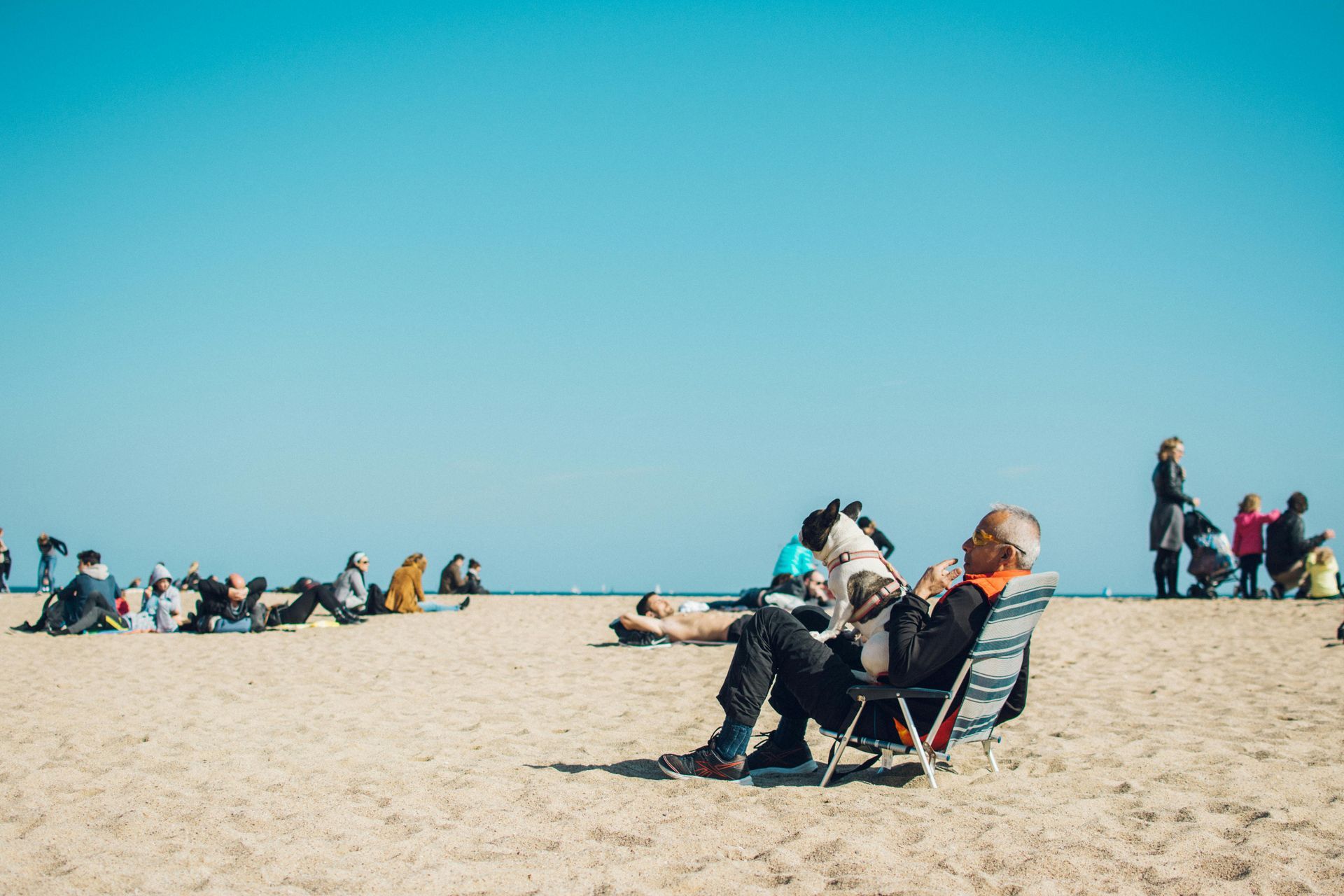 A man is sitting in a chair on the beach.