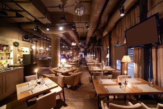 A restaurant with tables and chairs and candles on them