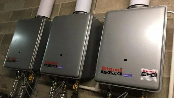 Three Gray Rinnai Water Heaters Mounted on a Wall — VR Marsden Plumbing in Red Rock, NSW