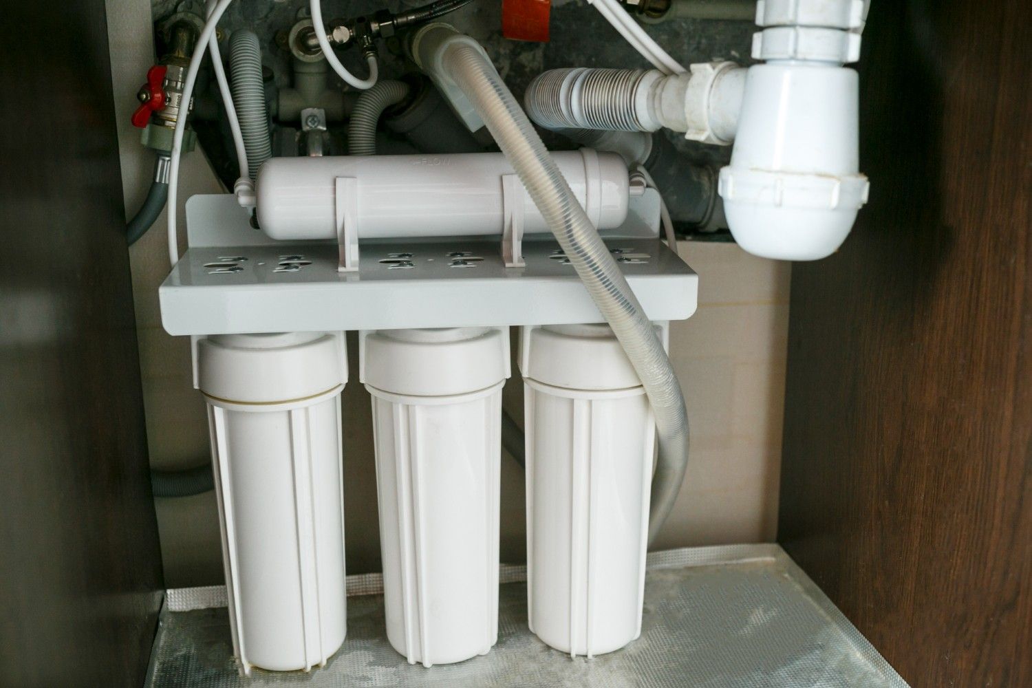 Water Filter System With Three White Cylindrical Filters Under a Sink — VR Marsden Plumbing in Red Rock, NSW