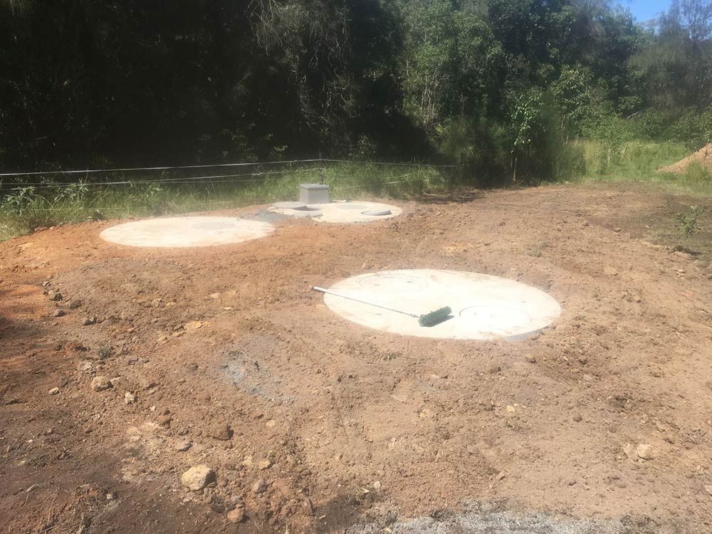 Three Concrete Circles and a Square Are in a Dirt Lot — VR Marsden Plumbing in Red Rock, NSW