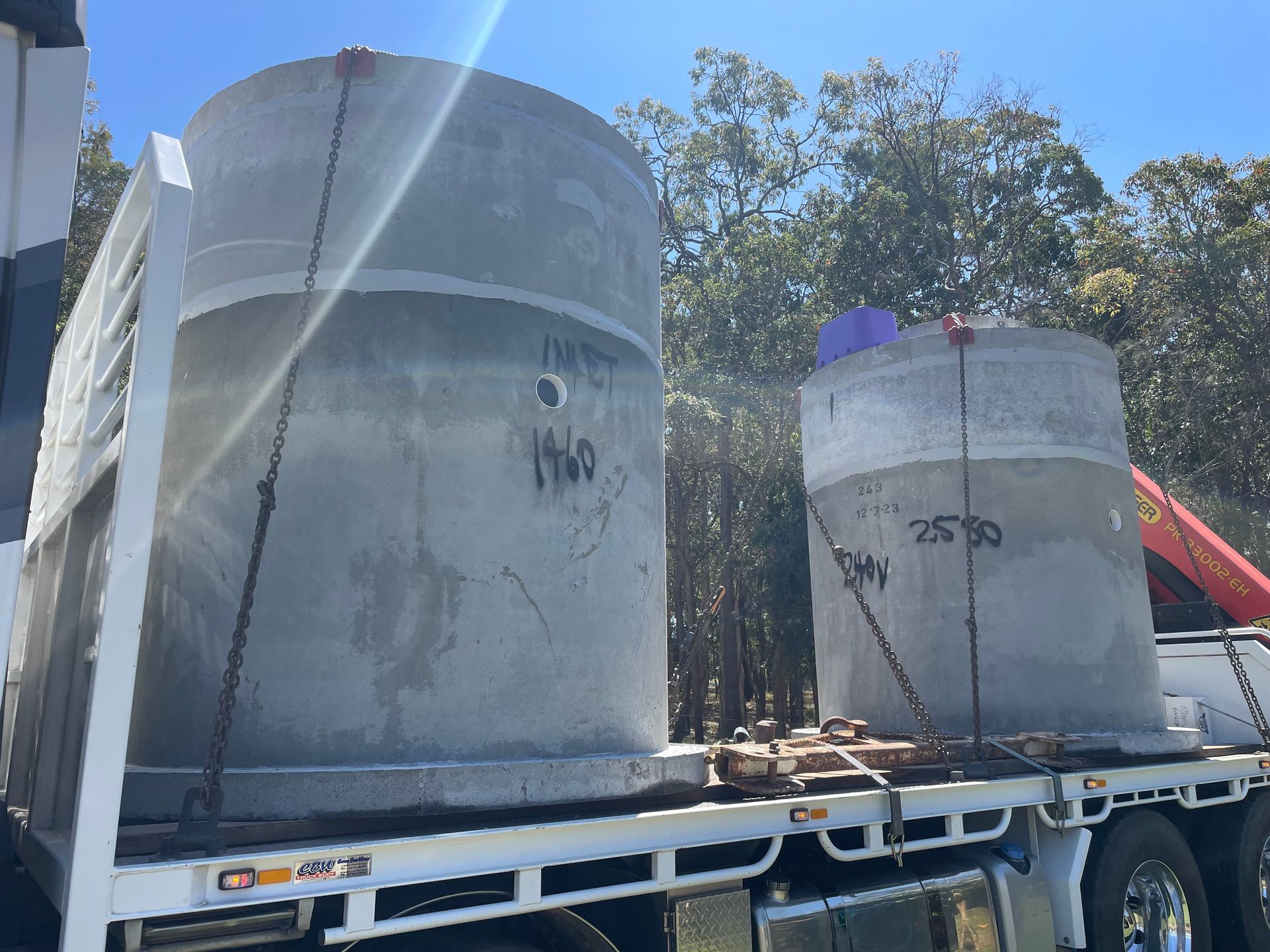 Two large concrete tanks are strapped onto the back of a truck — VR Marsden Plumbing in Red Rock, NSW