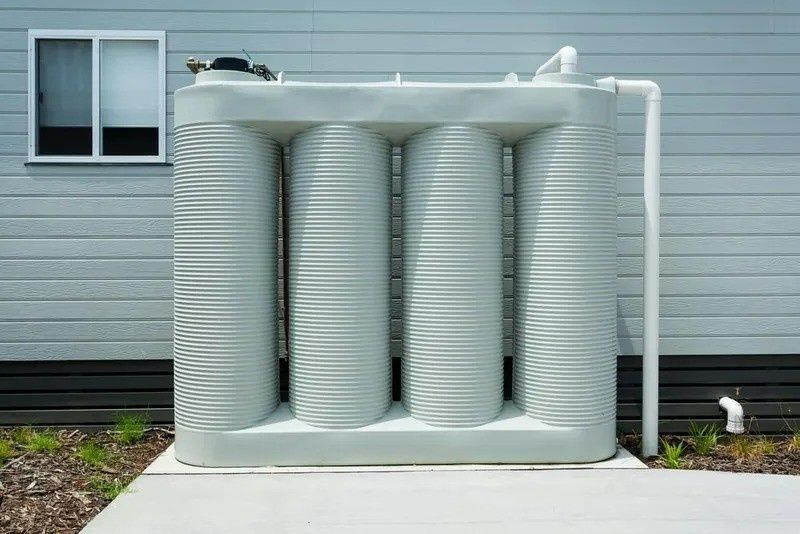 A Gray, Ribbed Water Tank Outside a House — VR Marsden Plumbing in Red Rock, NSW