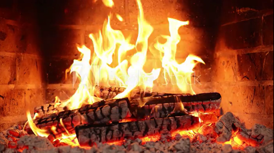 Burning logs in a brick fireplace with bright flames and glowing embers