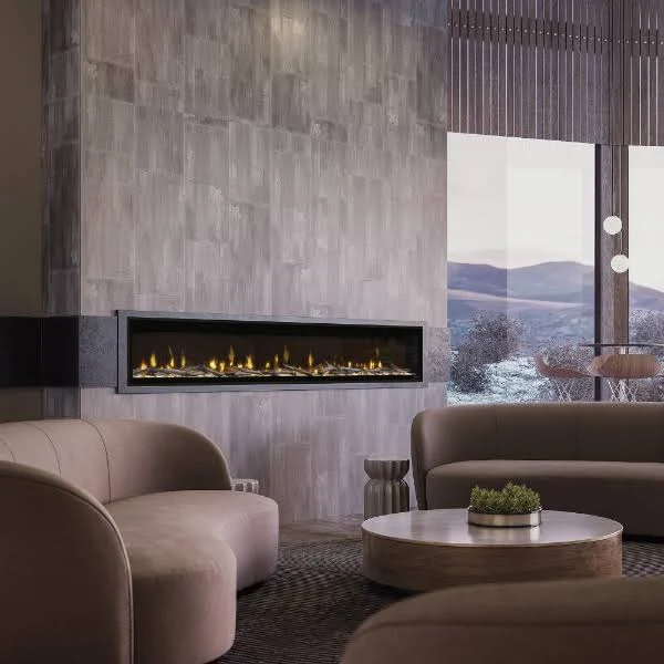 Cozy living room with a lit fireplace, black mantel, and a small framed dog portrait above it