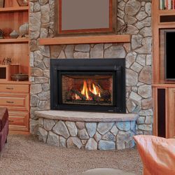 Cozy living room with a lit fireplace, black mantel, and a small framed dog portrait above it