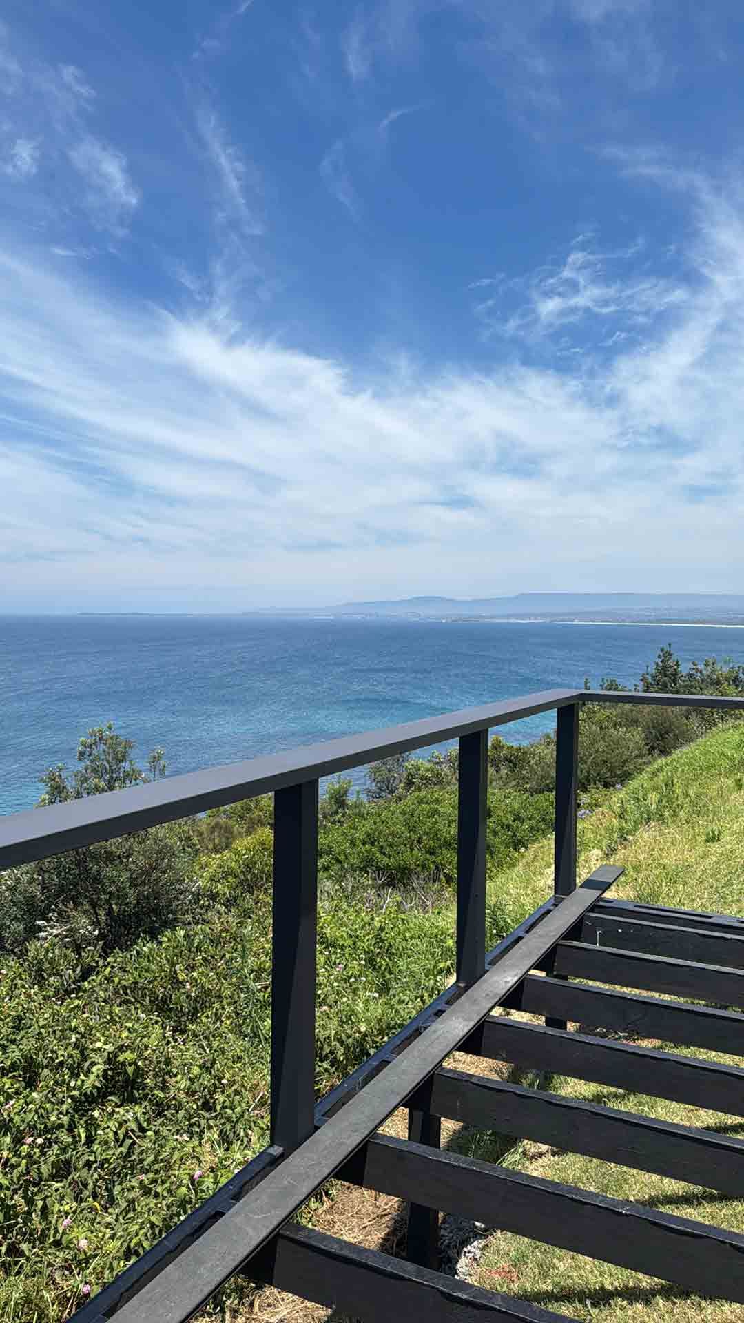 A Wooden Deck Overlooking the Ocean on a Sunny Day — Hart Projects Wollongong In Dapto, NSW