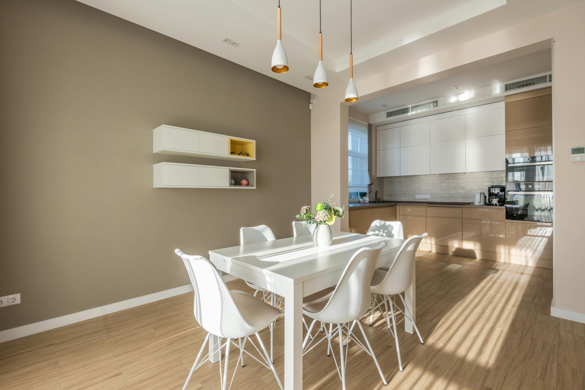 A dining room with a table and chairs and a kitchen in the background — Hart Projects Wollongong In Dapto, NSW