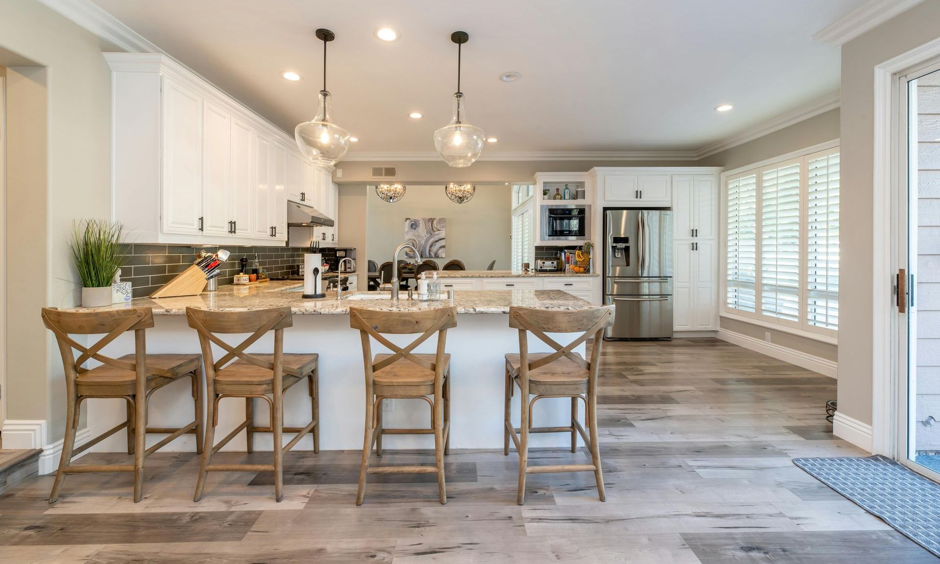 Modern kitchen with wooden bar stools and hanging lights — Hart Projects Wollongong In Dapto, NSW