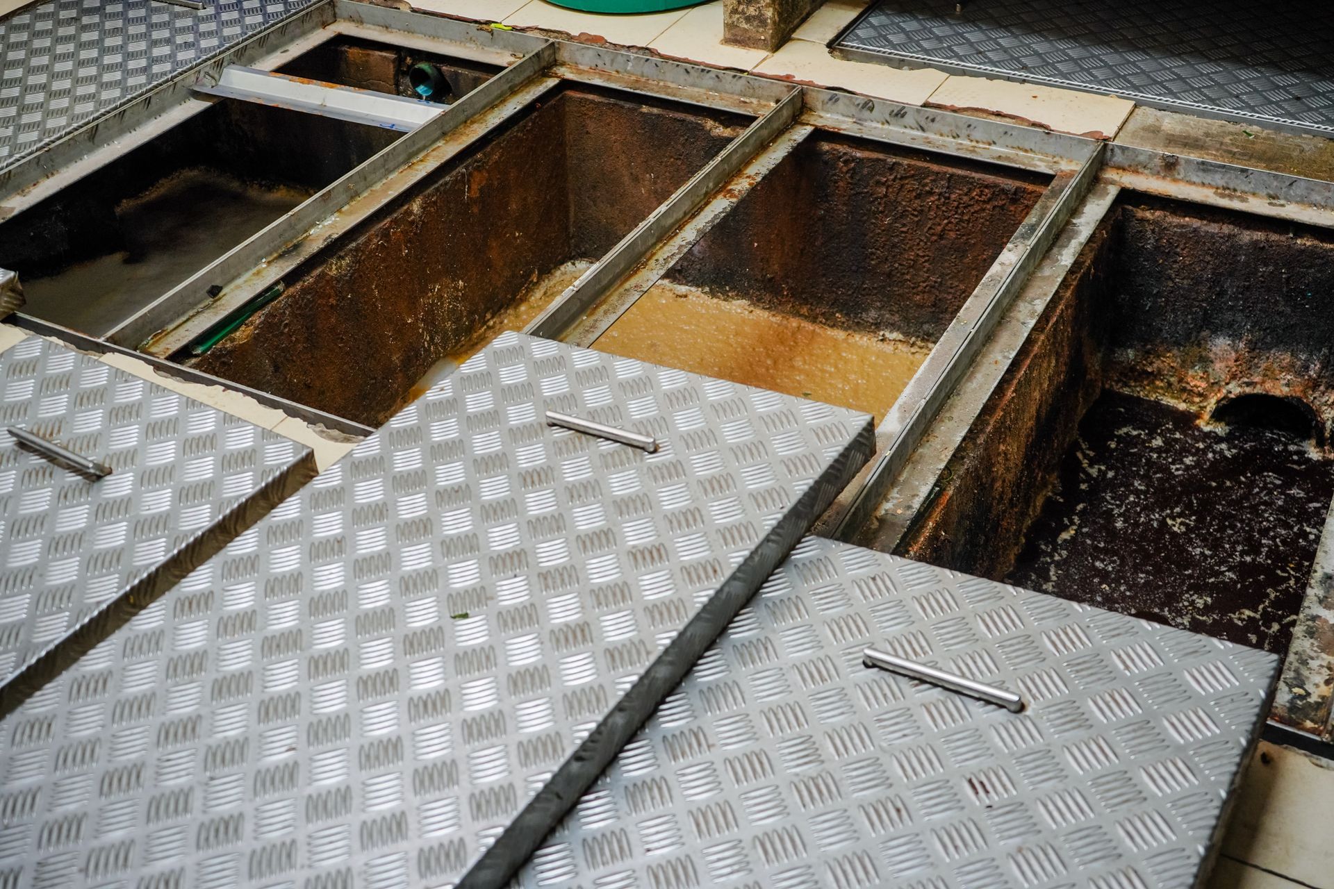 Open Metal Floor Panels Exposing Rectangular Maintenance Pits — Shreks Septic Services in Toowoomba, QLD