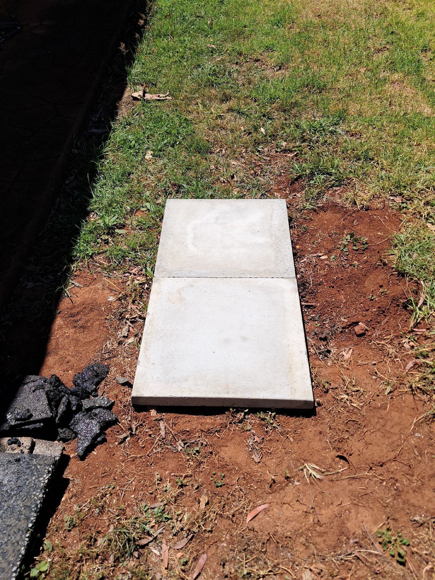 Two White Concrete Slabs in a Dirt Yard Beside Grass — Shreks Septic Services in Pittsworth, QLD