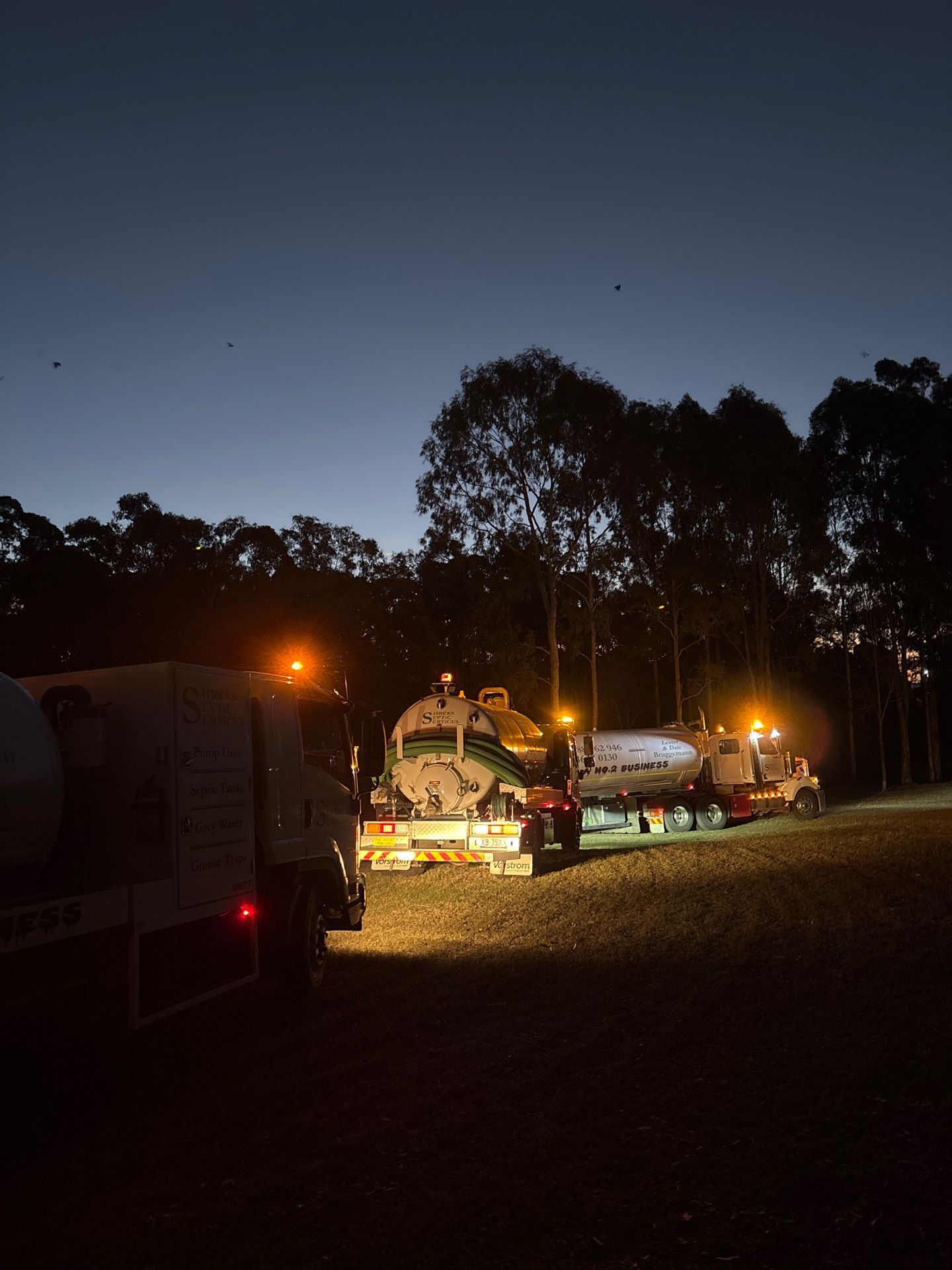Nighttime Outdoor Scene With Lit Trailers — Shreks Septic Services in Dalby, QLD