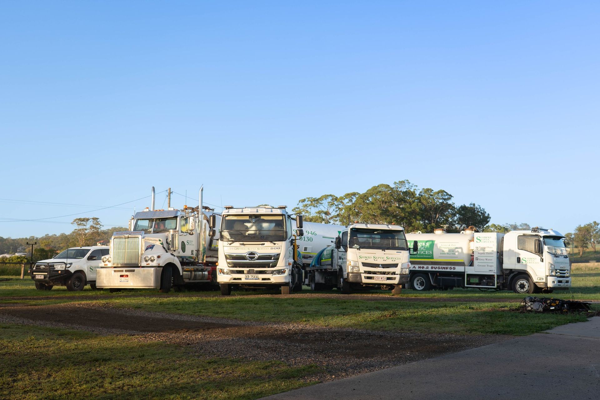 Three White Utility Trucks Parked — Shreks Septic Services in Helidon, QLD