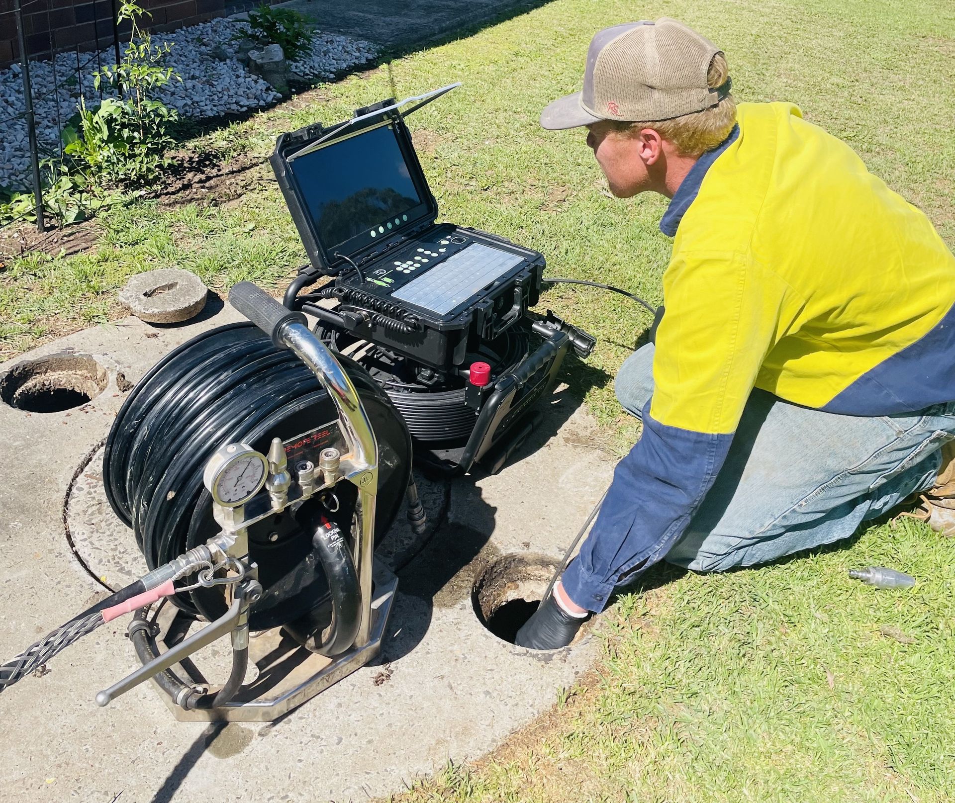 Technician in Yellow Shirt Inspecting a Sewer LINE — Shreks Septic Services in Highfields, QLD