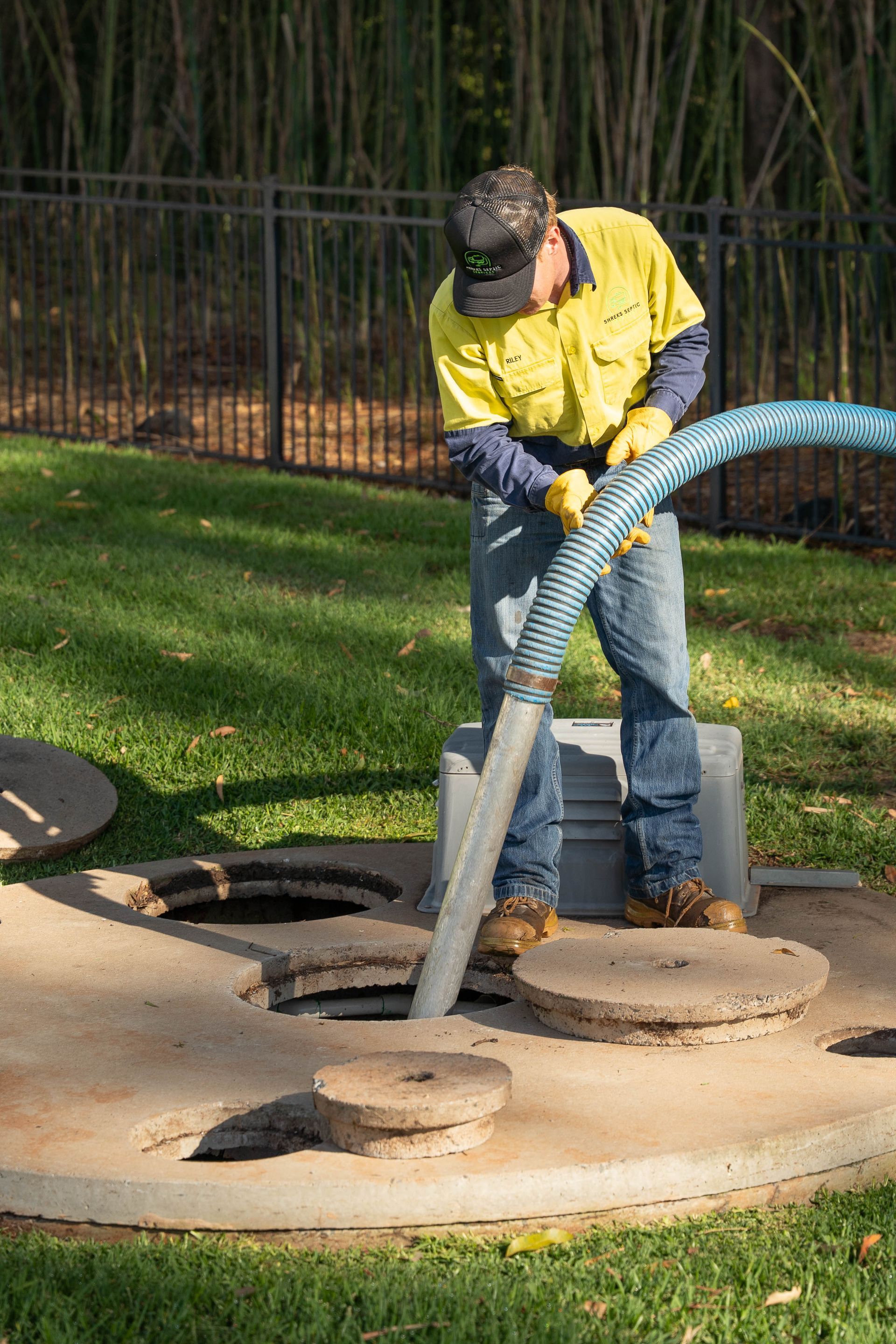 Worker Using a Vacuum Hose to Clean Debris — Shreks Septic Services in Hampton, QLD