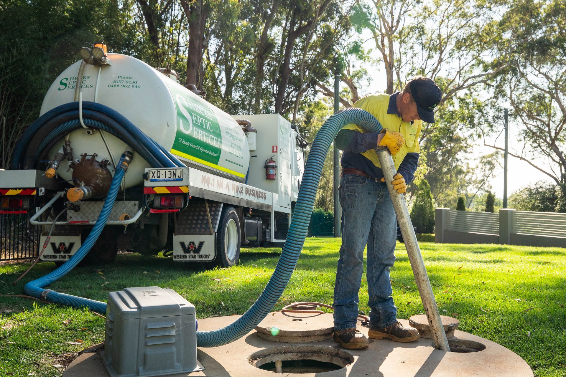 Worker Spraying Liquid From a Tanker Truck — Shreks Septic Services in Crows Nest, QLD