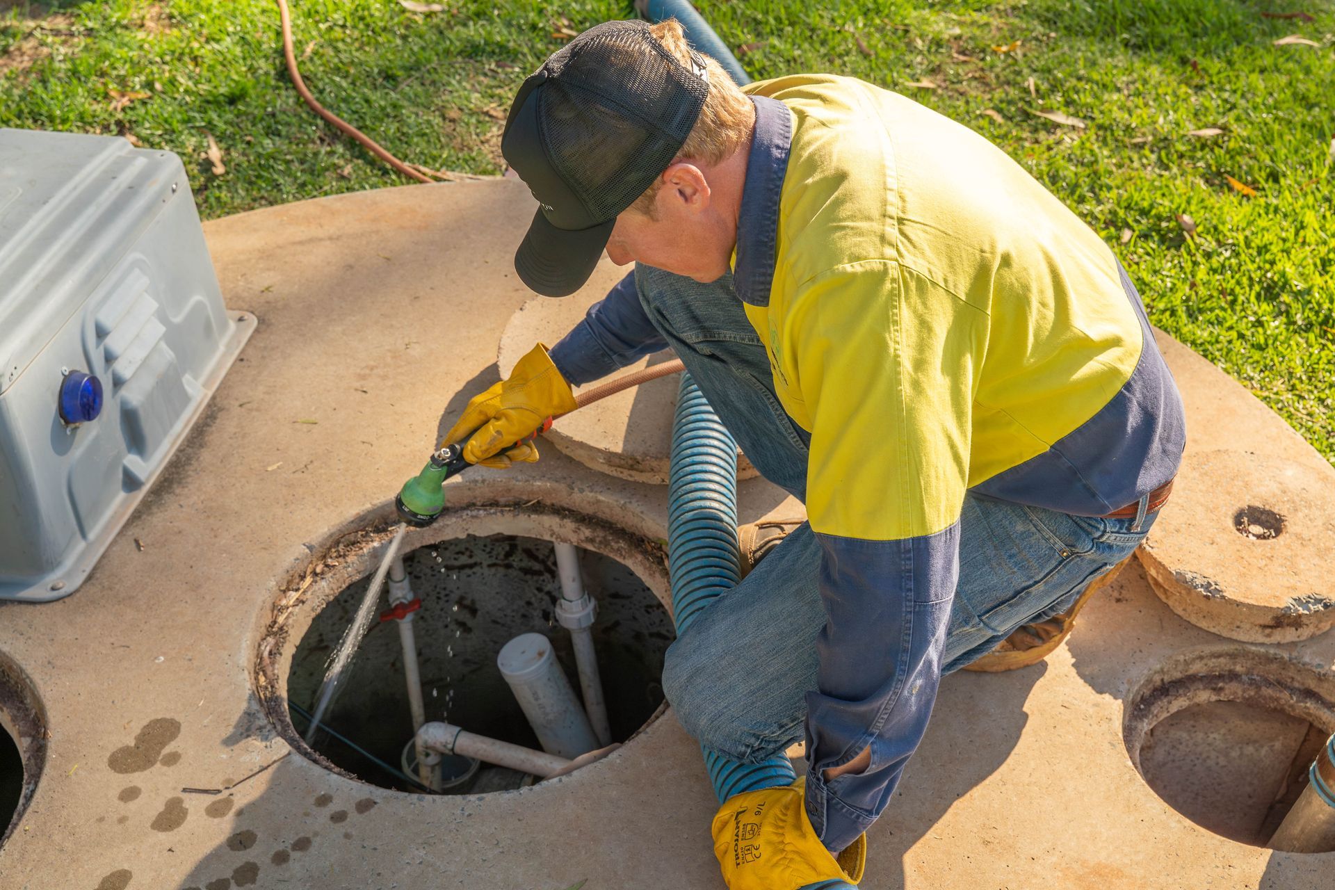 Worker in Yellow Shirt and Gloves Inspecting — Shreks Septic Services in Dalby, QLD