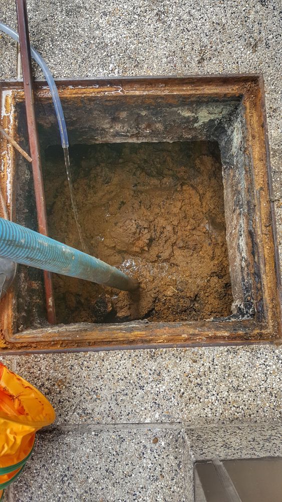 A Person Cleaning a Sludge — Shreks Septic Services in Dalby, QLD
