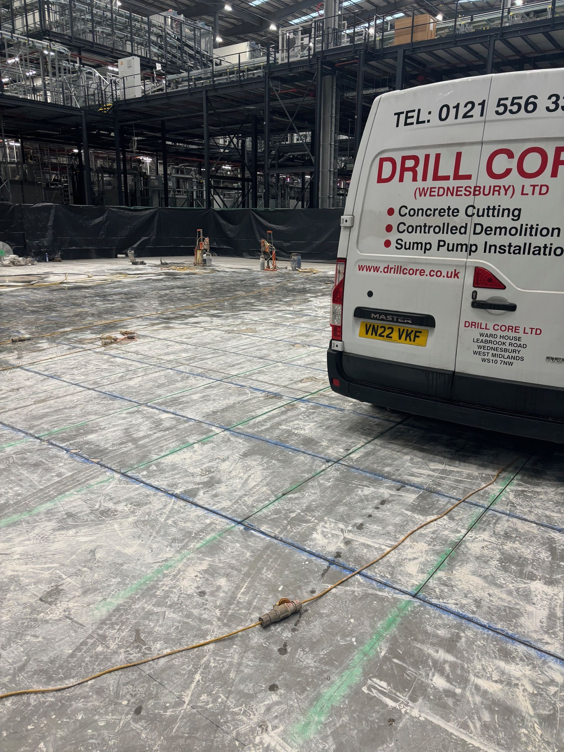 A white van is parked in a construction site.