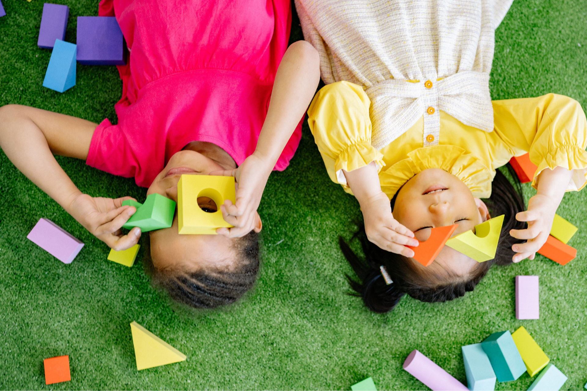 children laying down playing with blocks