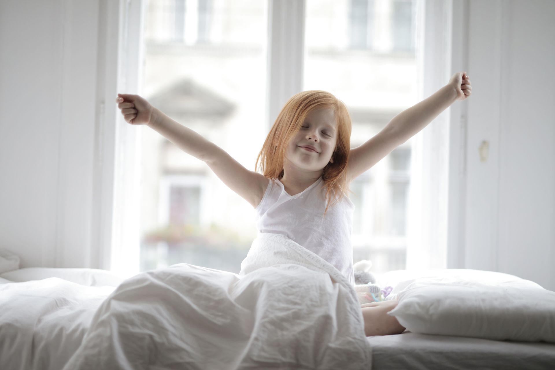 child waking up in bed and stretching