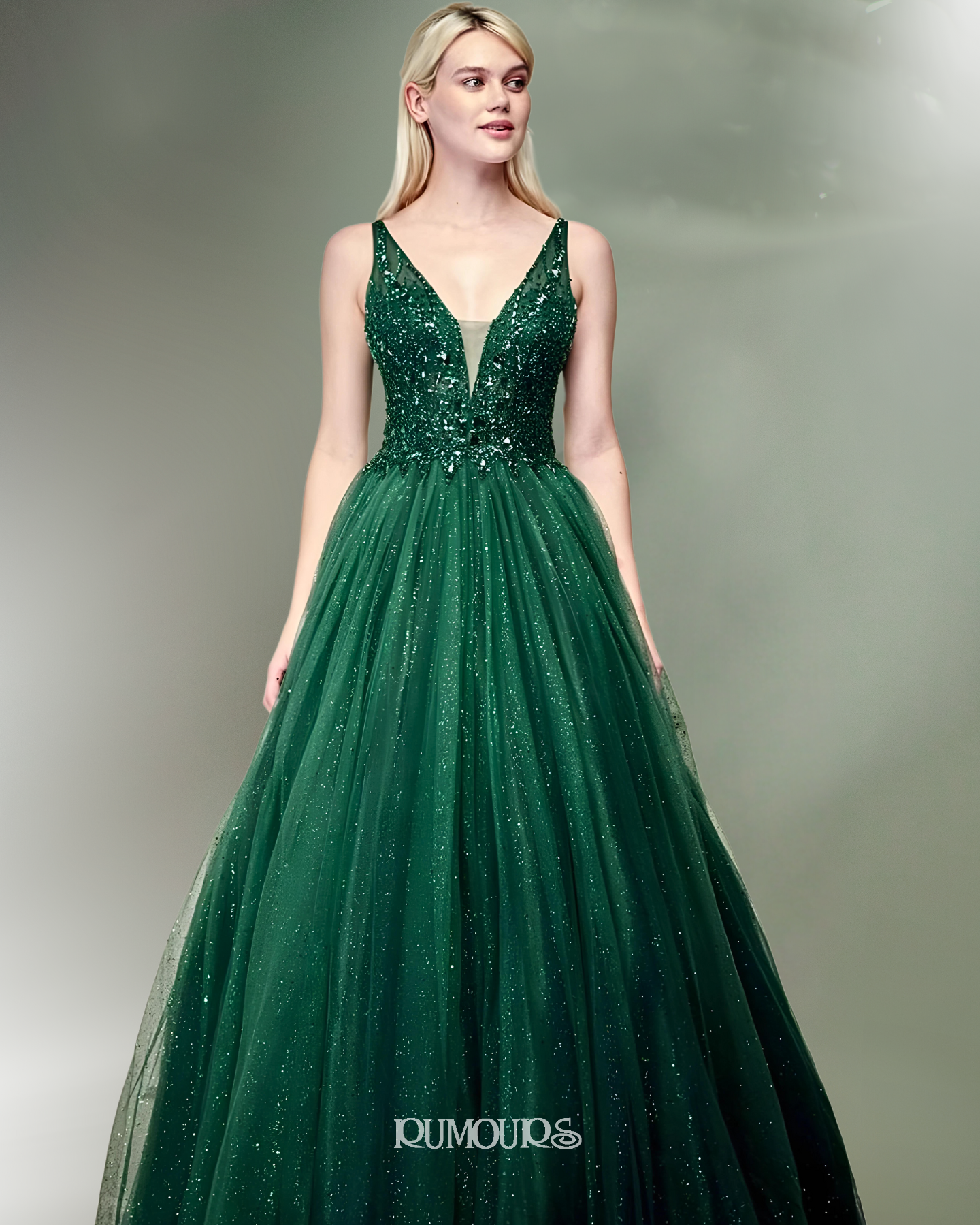 Woman in a sparkling emerald green gown with a plunging neckline.