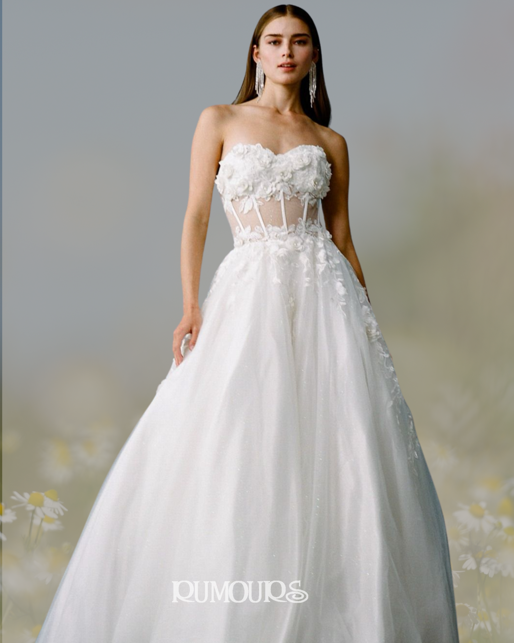 Woman in a white strapless wedding gown with floral embellishments; soft, blurred background.