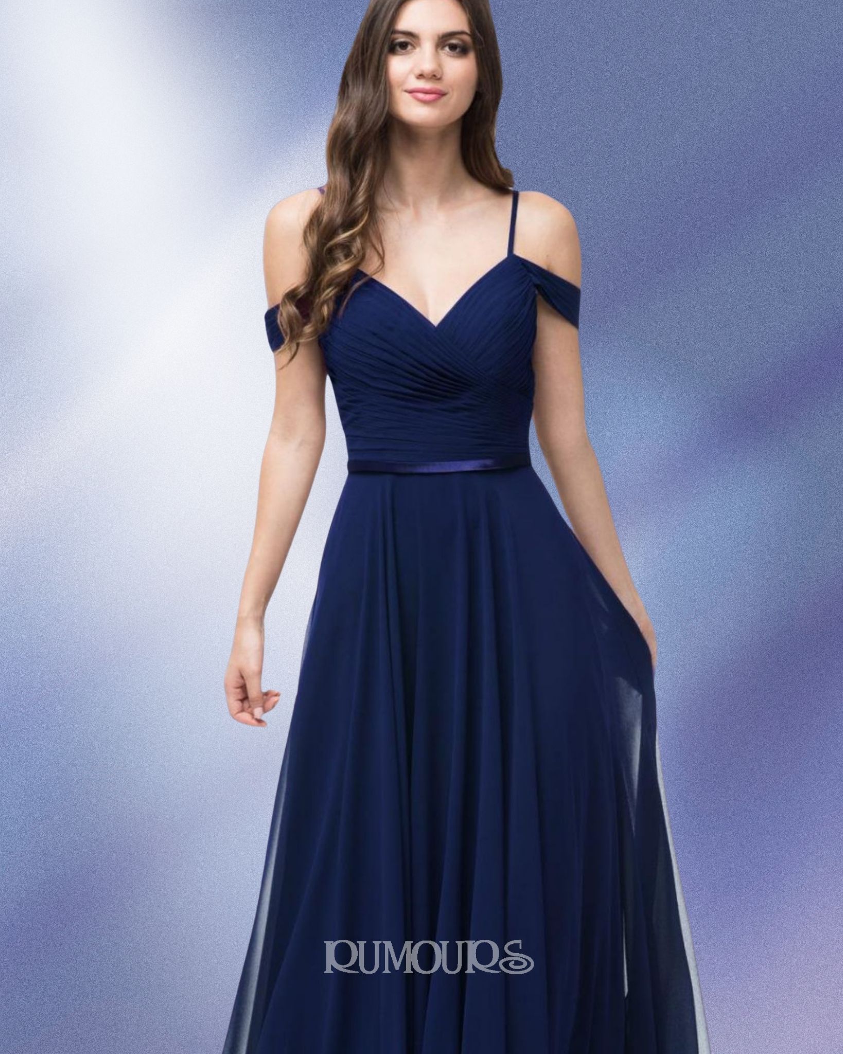 Woman in a navy blue off-the-shoulder dress with a sweetheart neckline, standing in front of a blue background.