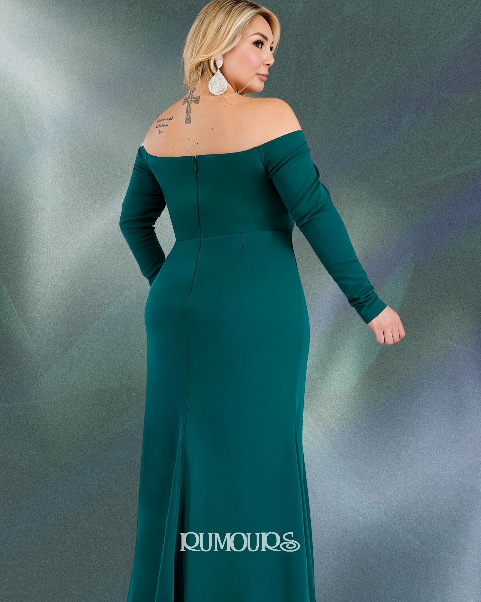 Woman in a green off-the-shoulder gown, posing with her back to the camera.