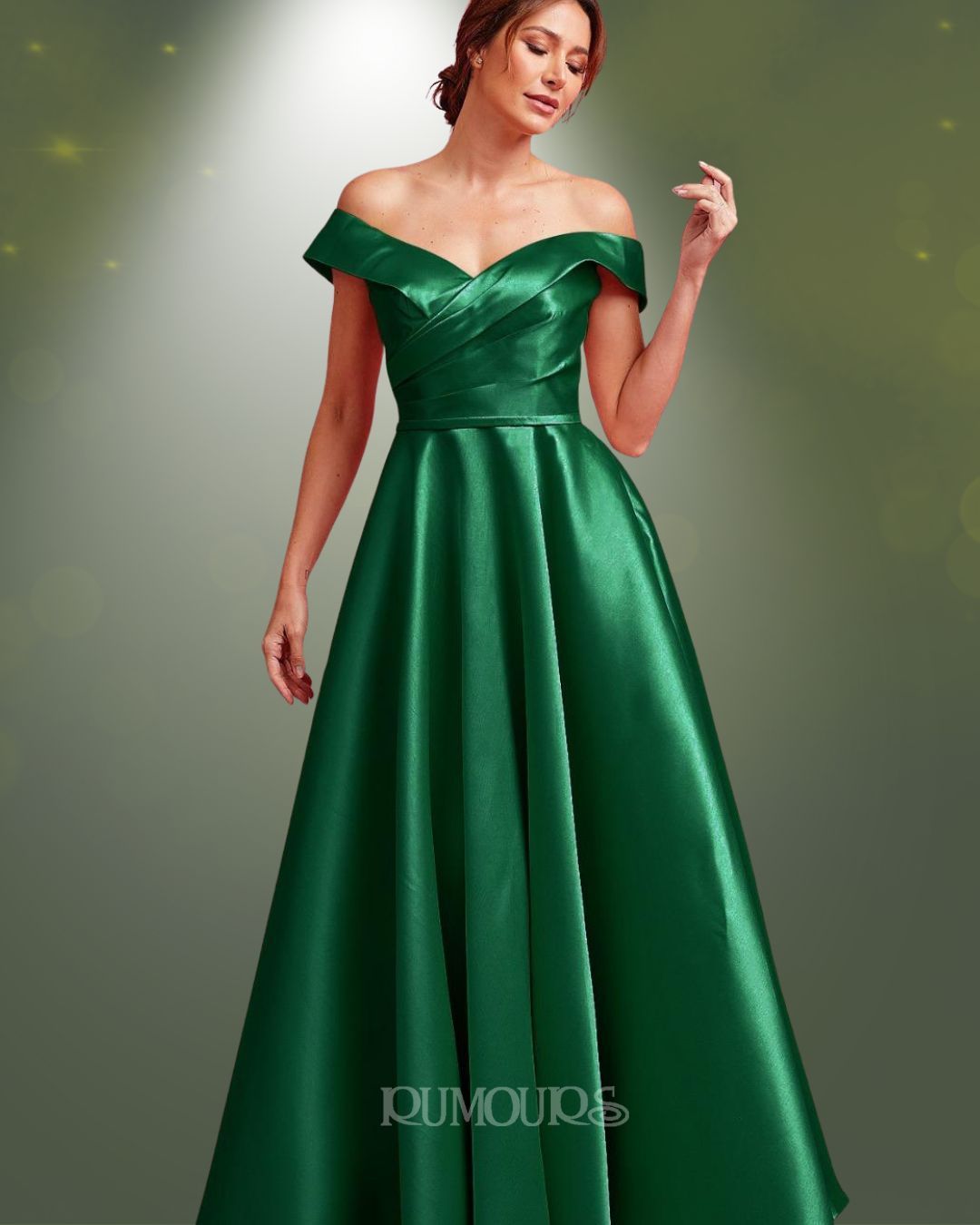 Woman in a green off-the-shoulder formal gown, posing against a gradient background.
