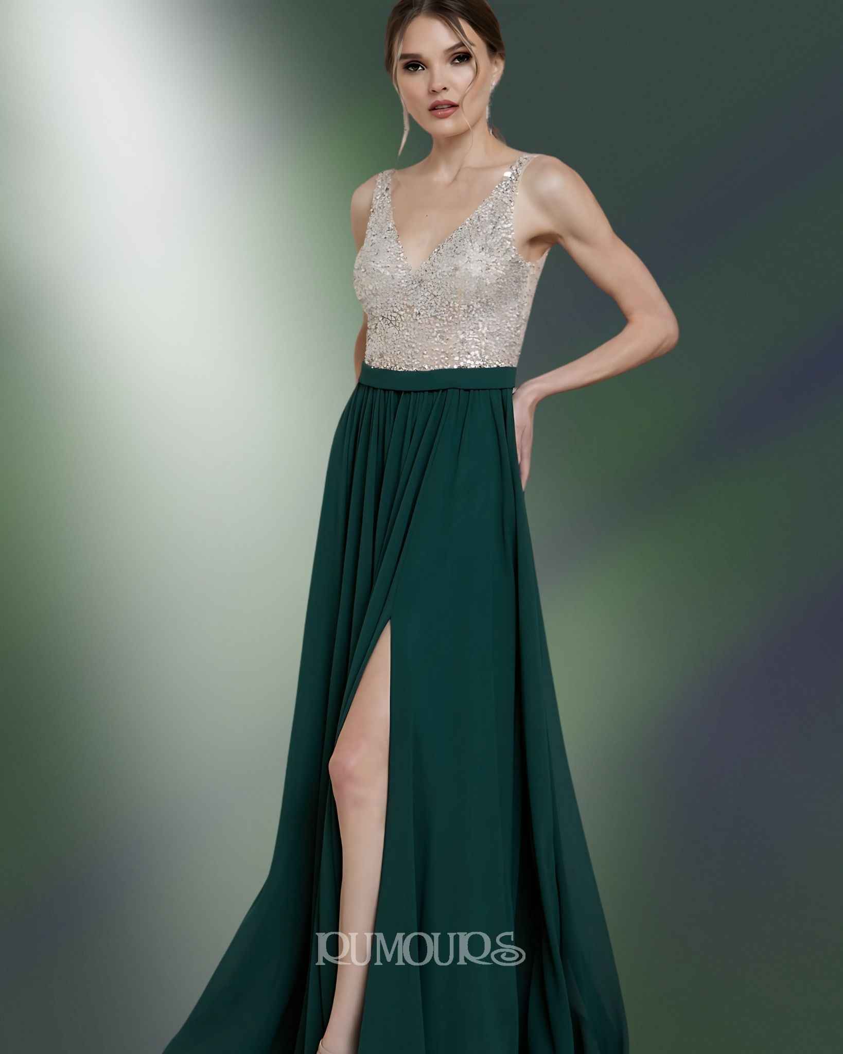 Woman in a formal emerald green dress with a high slit, sequined bodice, posing in front of a blurred background.