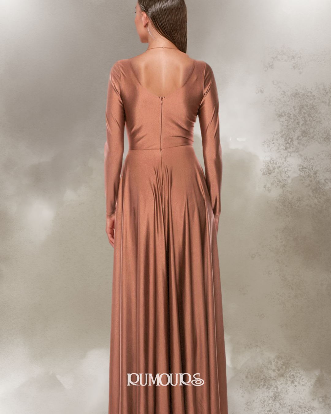 Woman in bronze gown, back view. Long sleeves, fitted bodice, flowing skirt. Neutral background.
