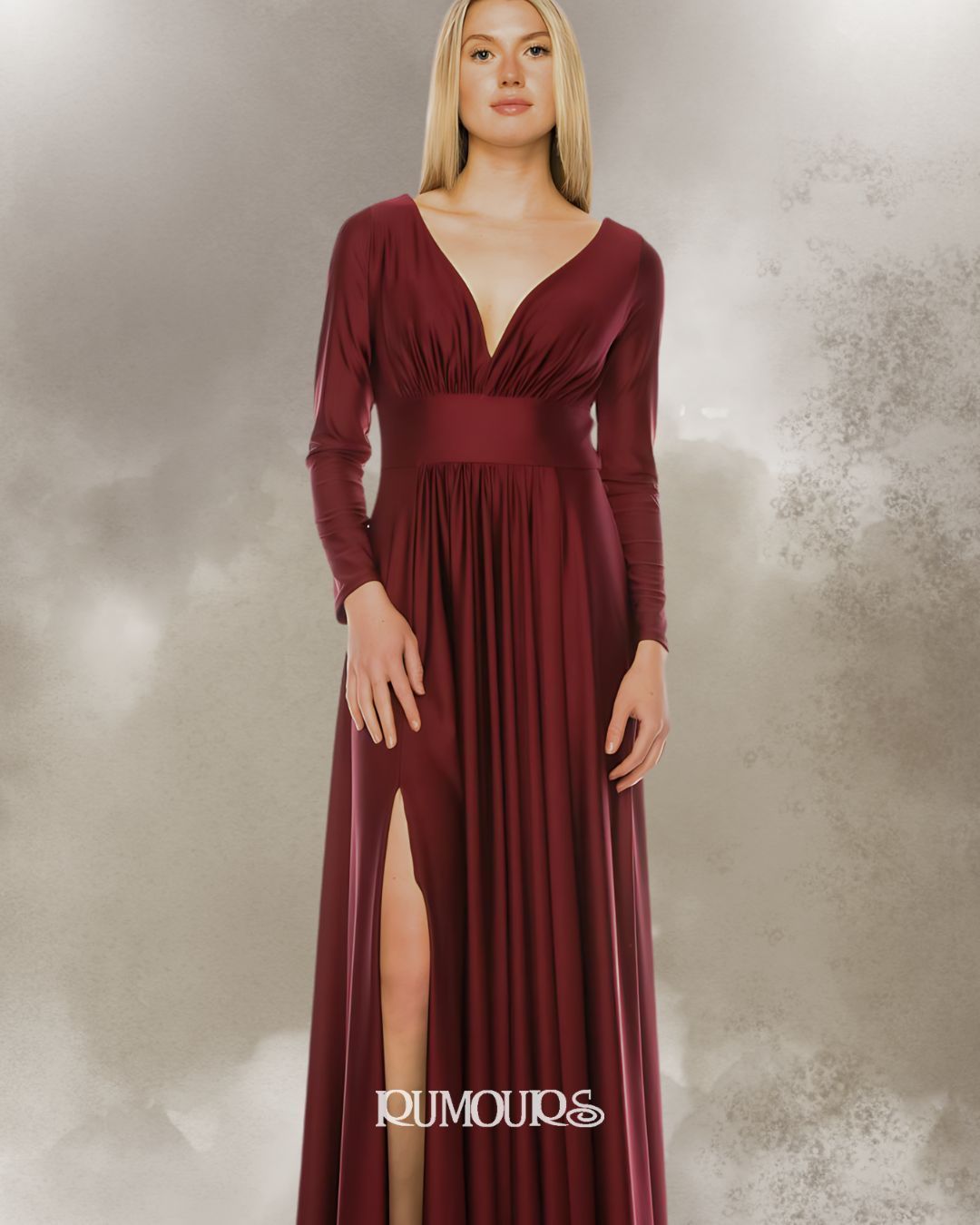 Woman in a burgundy, long-sleeved formal dress with a deep v-neck and a high slit.