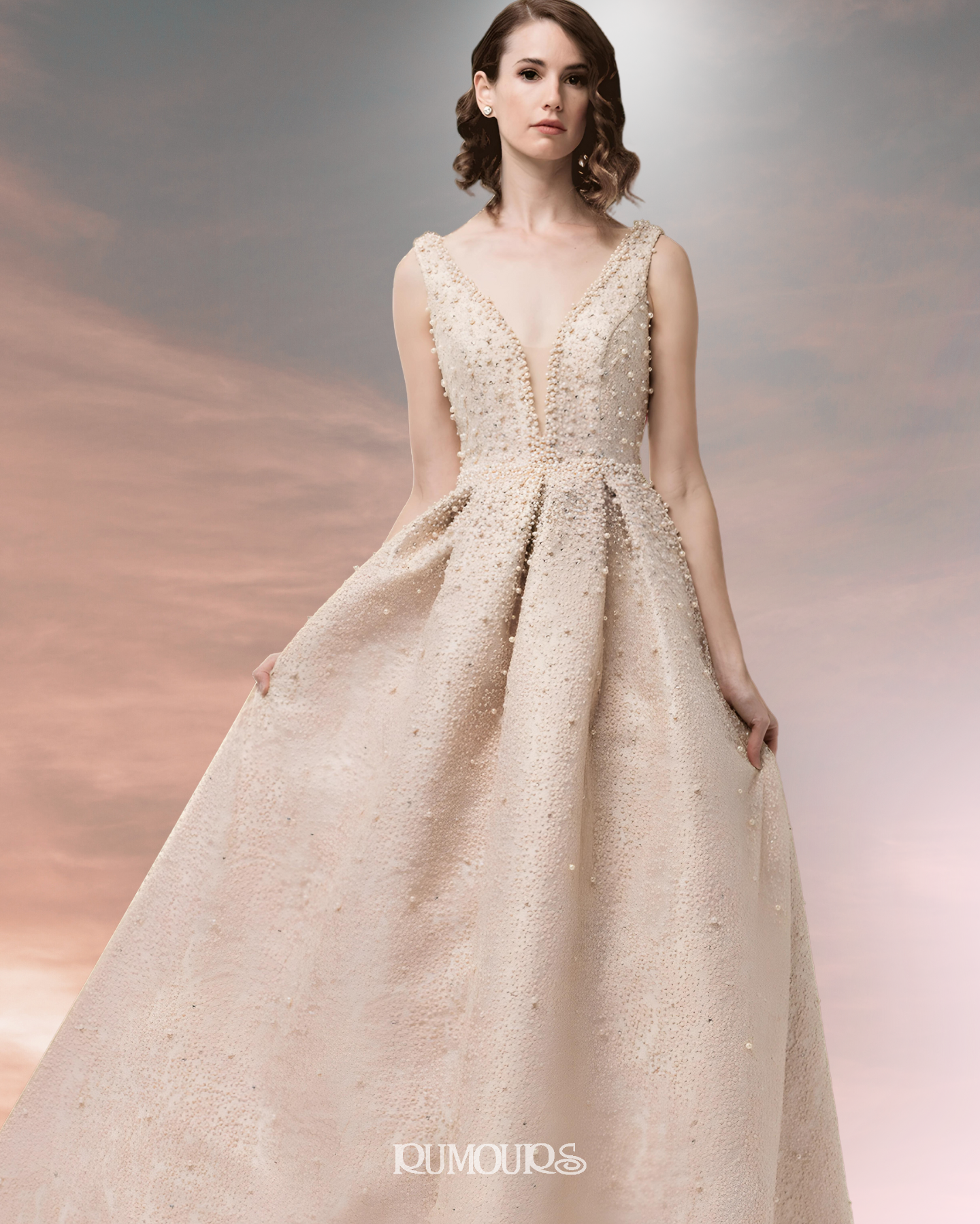 Woman in a formal, sleeveless gown with a deep V-neck and embellished bodice, standing.
