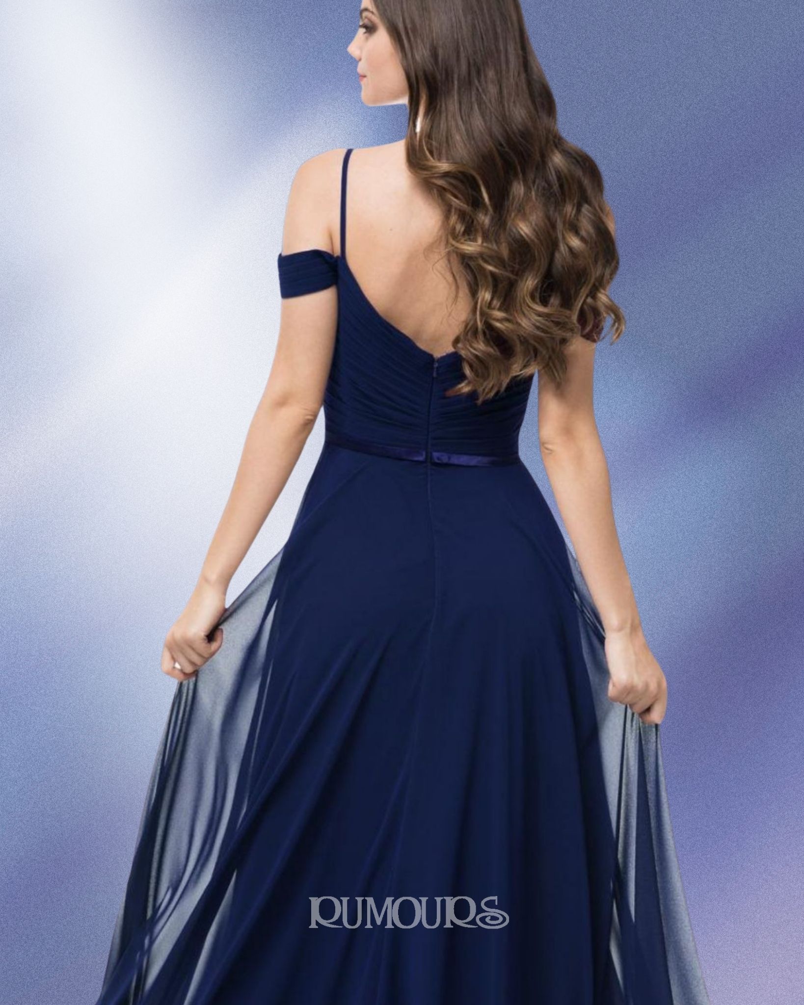 Woman in a navy blue formal gown, holding up the skirt.