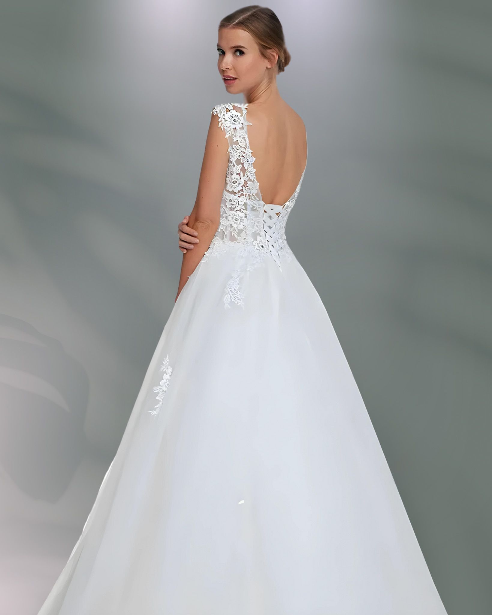 Woman in white wedding dress, back view, low back lace bodice, full skirt.