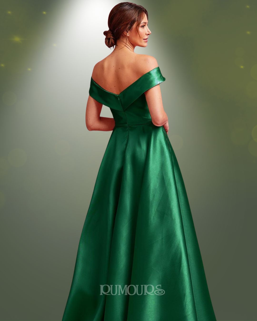 Woman in an emerald green off-the-shoulder gown, back view.