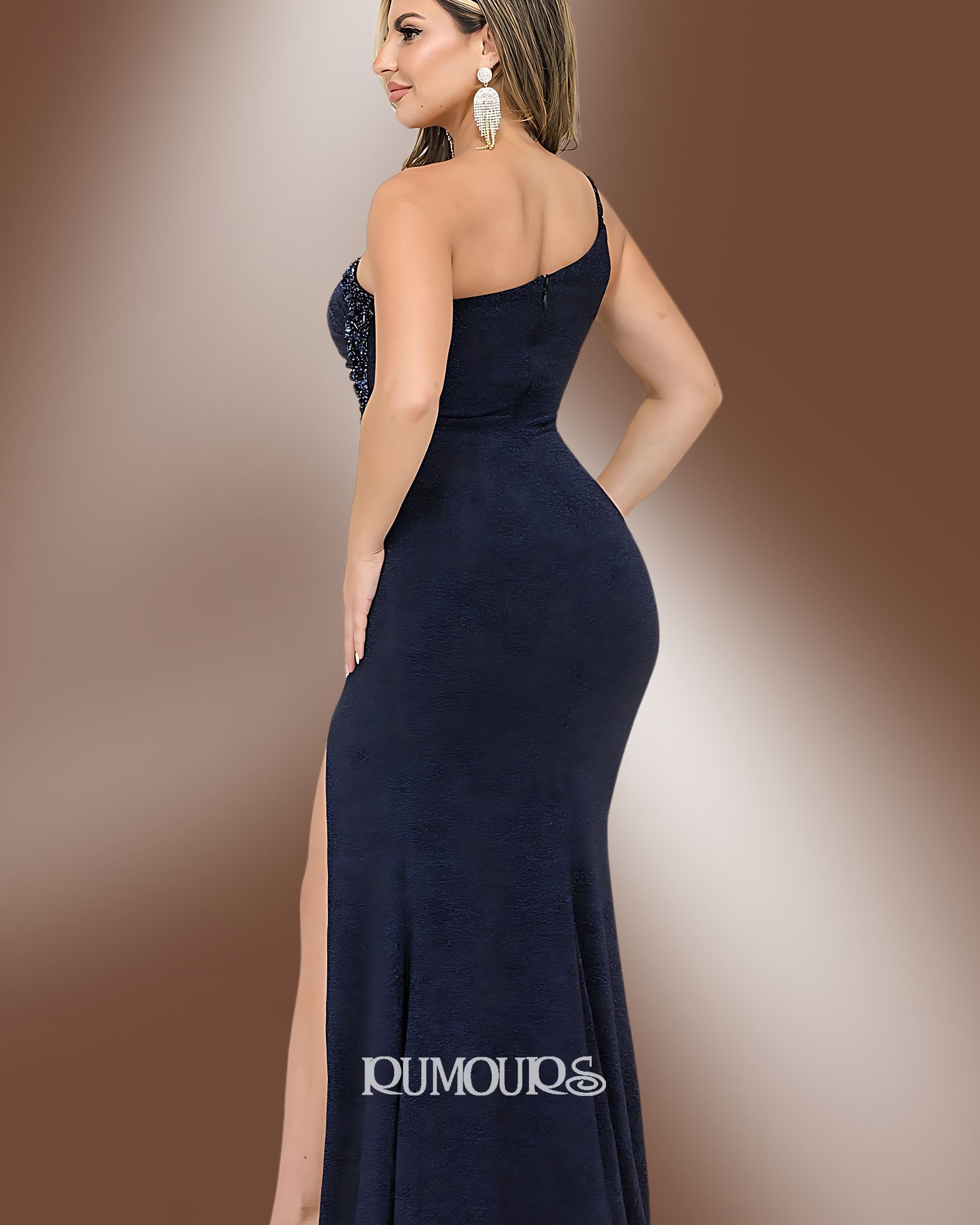 Woman in a navy blue, one-shoulder formal gown with a high slit, posing indoors.
