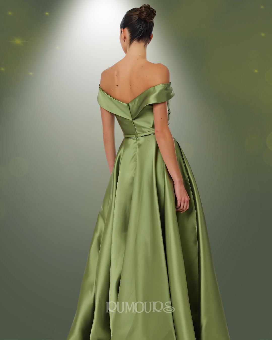 Woman in olive green off-the-shoulder gown, standing with back to the camera, against a soft green gradient.