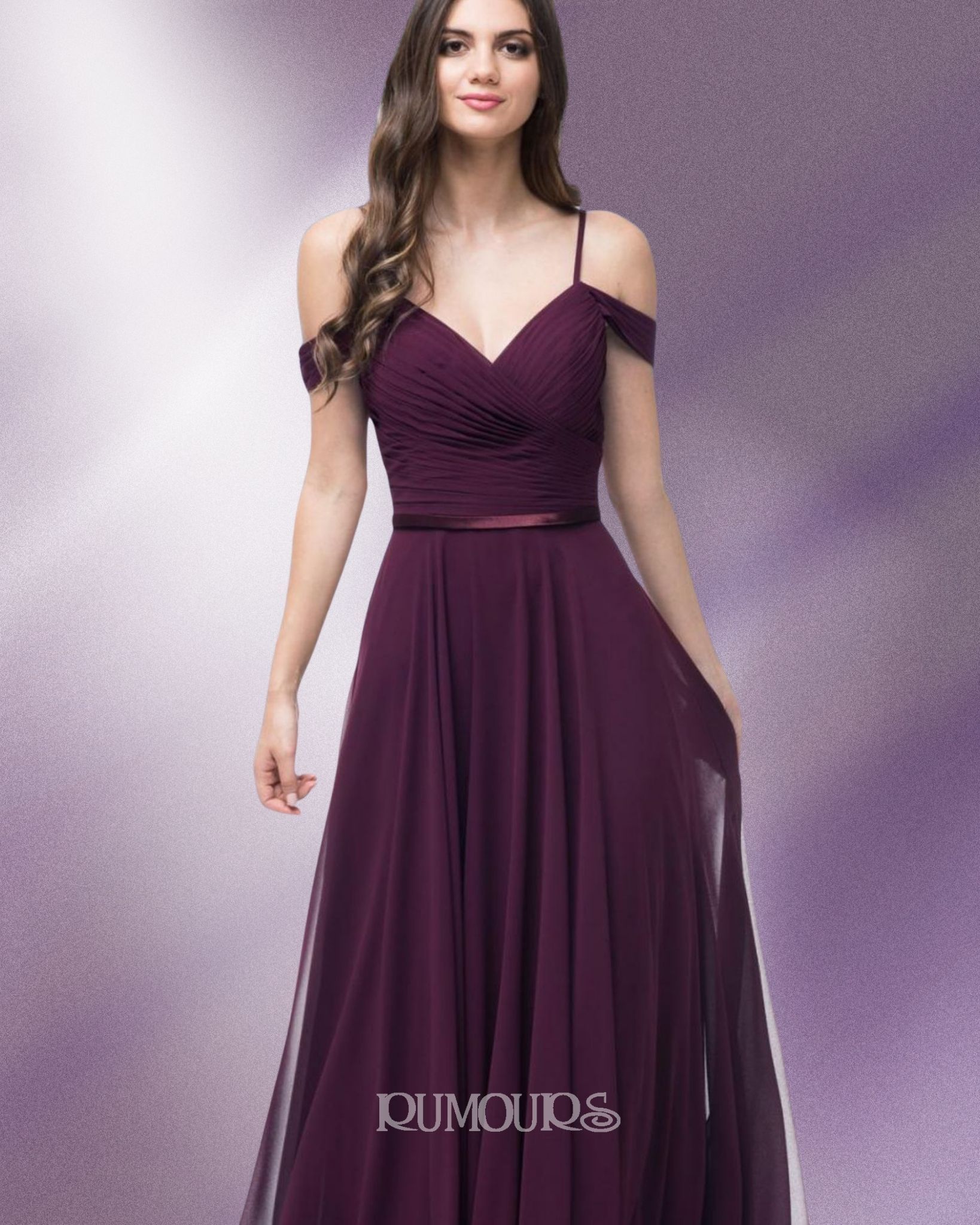 Woman in a plum-colored formal gown with off-the-shoulder straps, posed against a soft purple background.