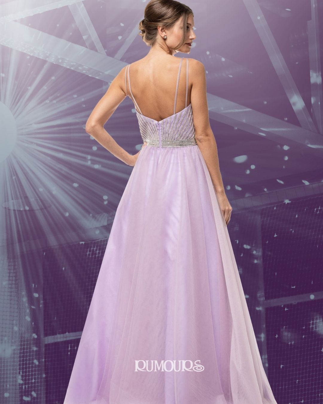 Woman in a lavender formal gown with embellished bodice, standing with hand on hip.