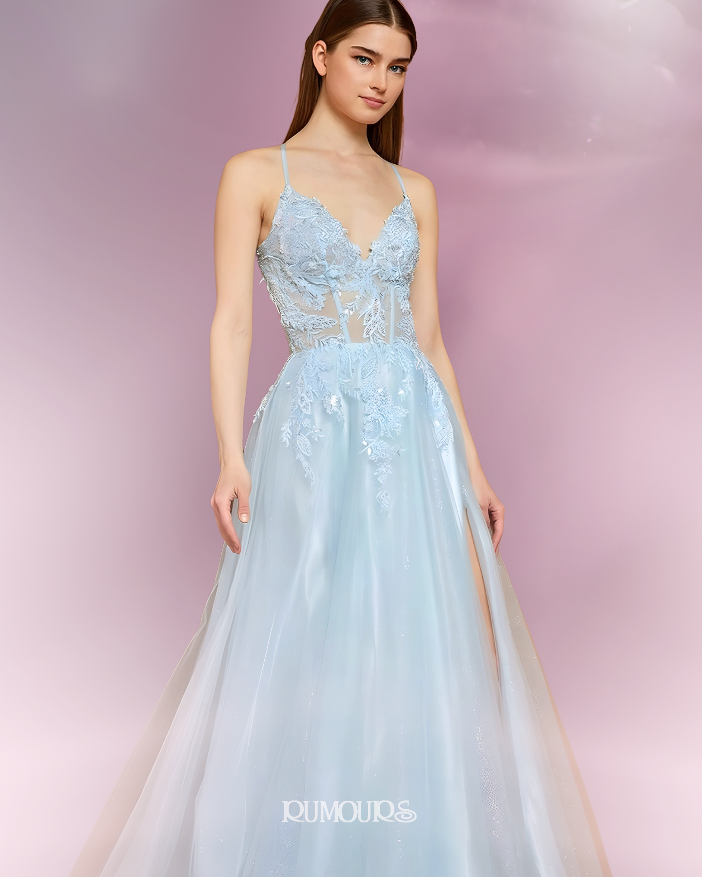 Woman in light blue formal gown with floral bodice, posing.