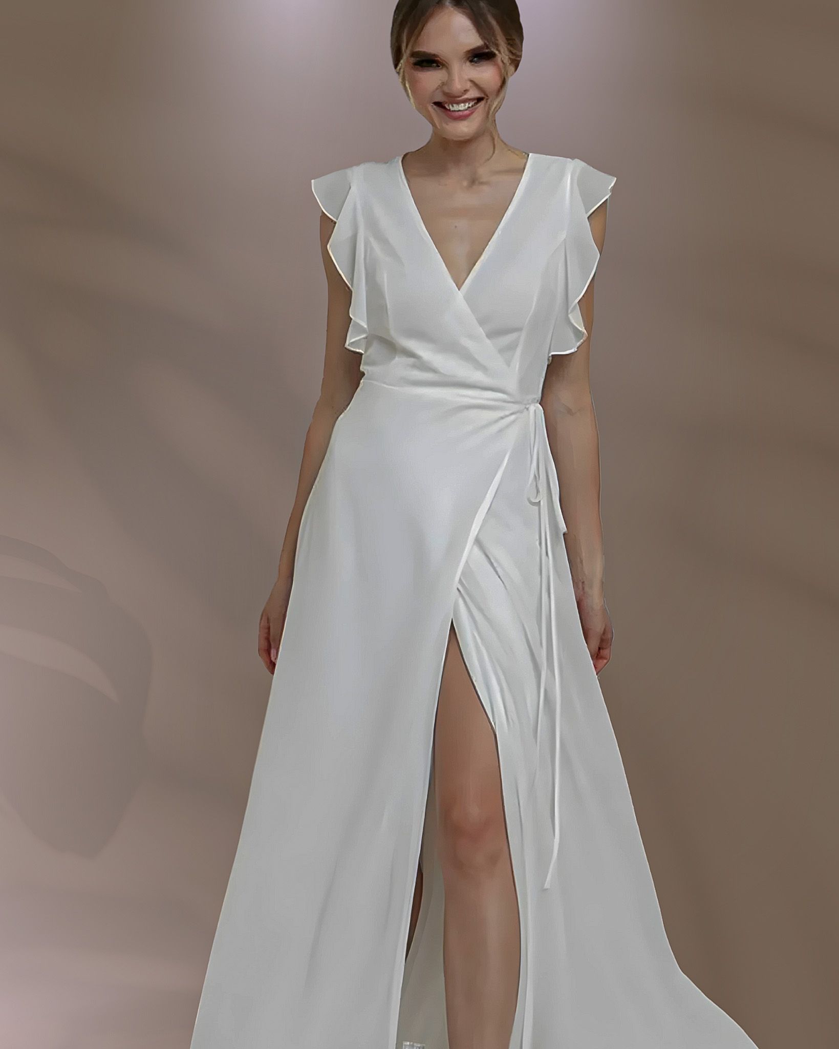 Woman in white wedding dress with high slit, smiling.