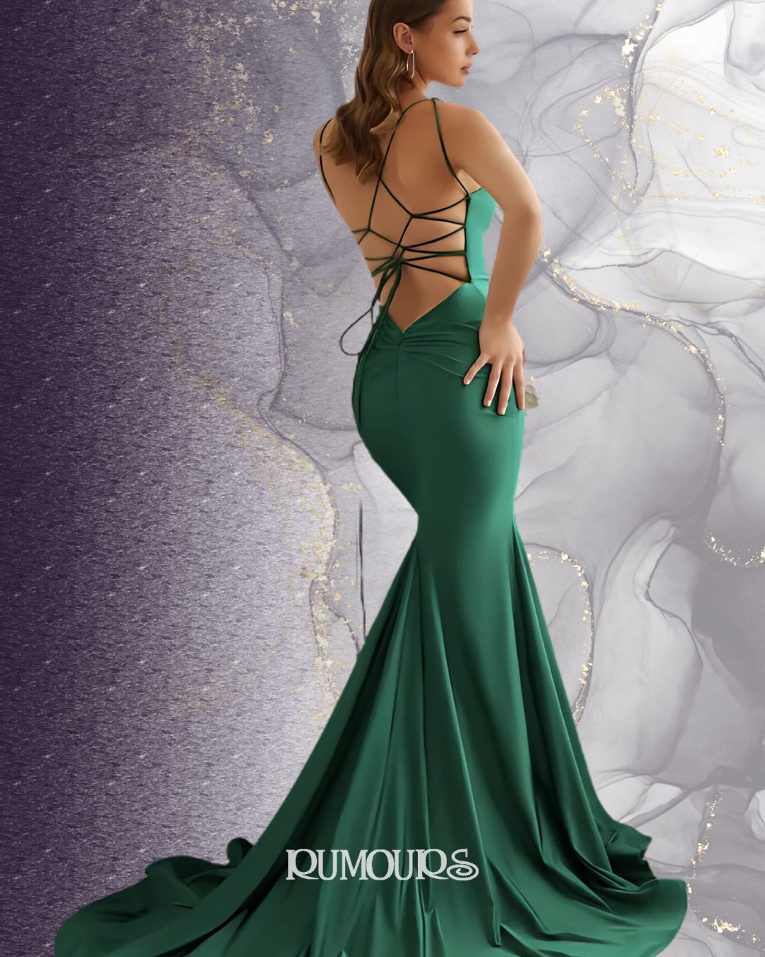 Woman in a green formal dress with a backless design and a long train, posing.