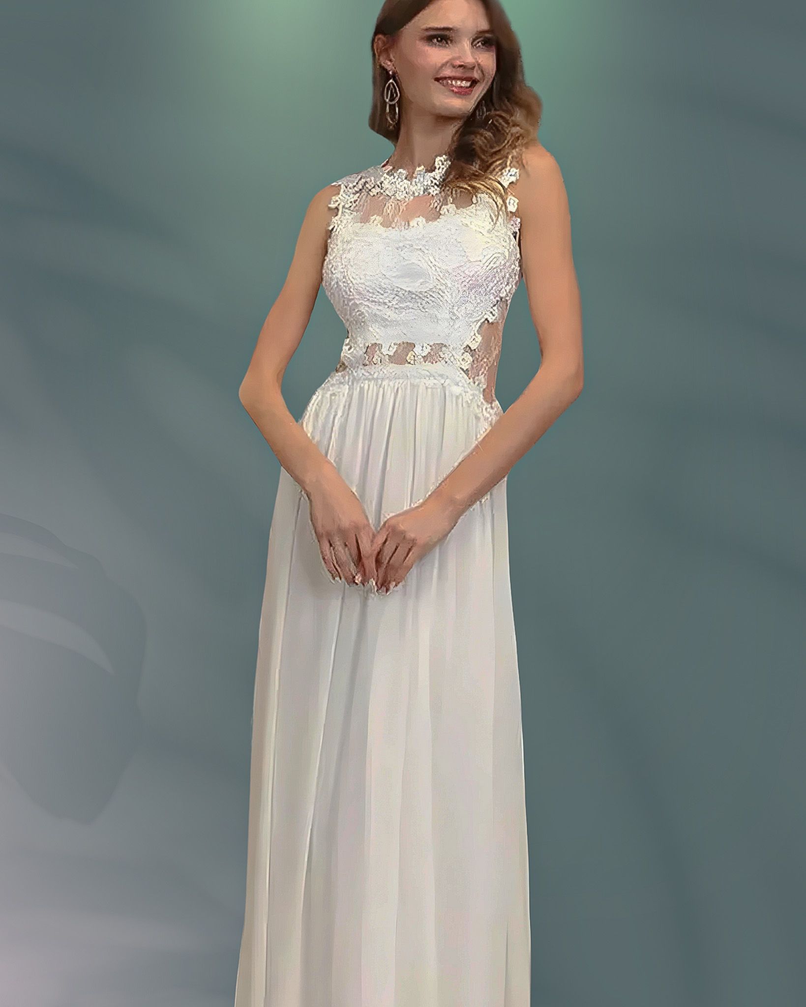 Woman in a white sleeveless gown with floral bodice, hands clasped, smiling, in a studio setting.
