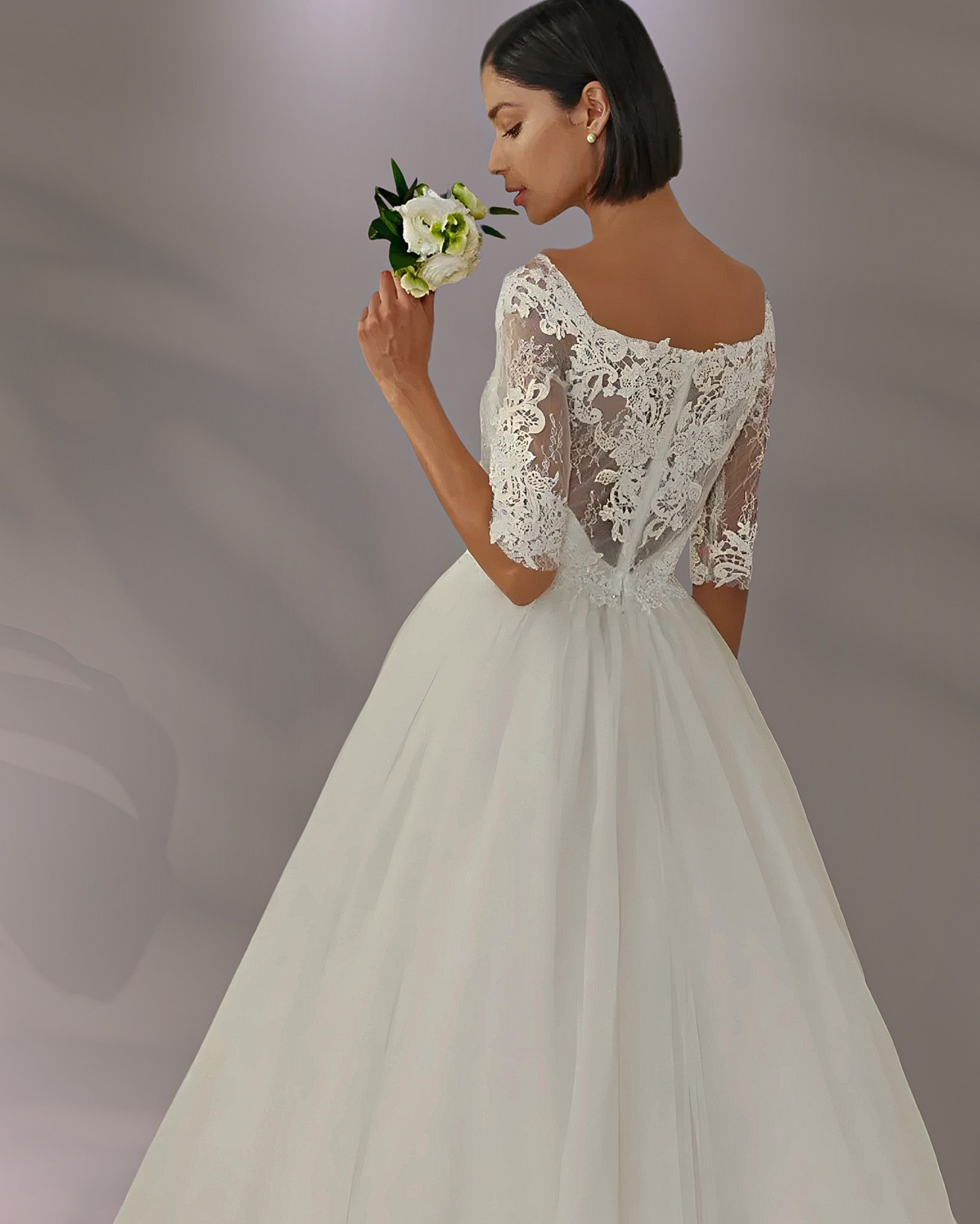 Woman in white wedding dress holding flowers.