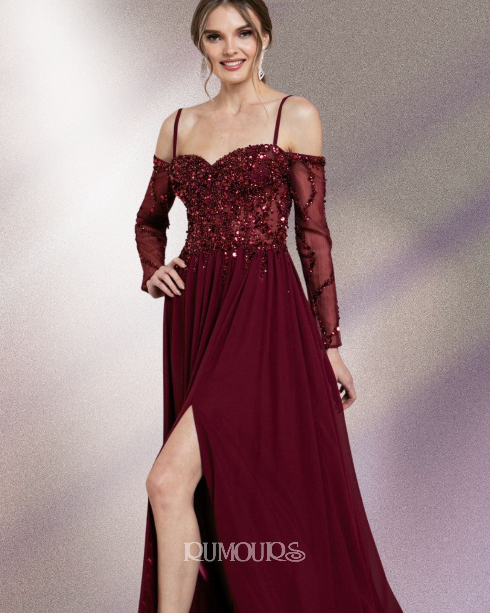 Woman in a burgundy off-the-shoulder gown with long sleeves and a high slit poses against a textured background.