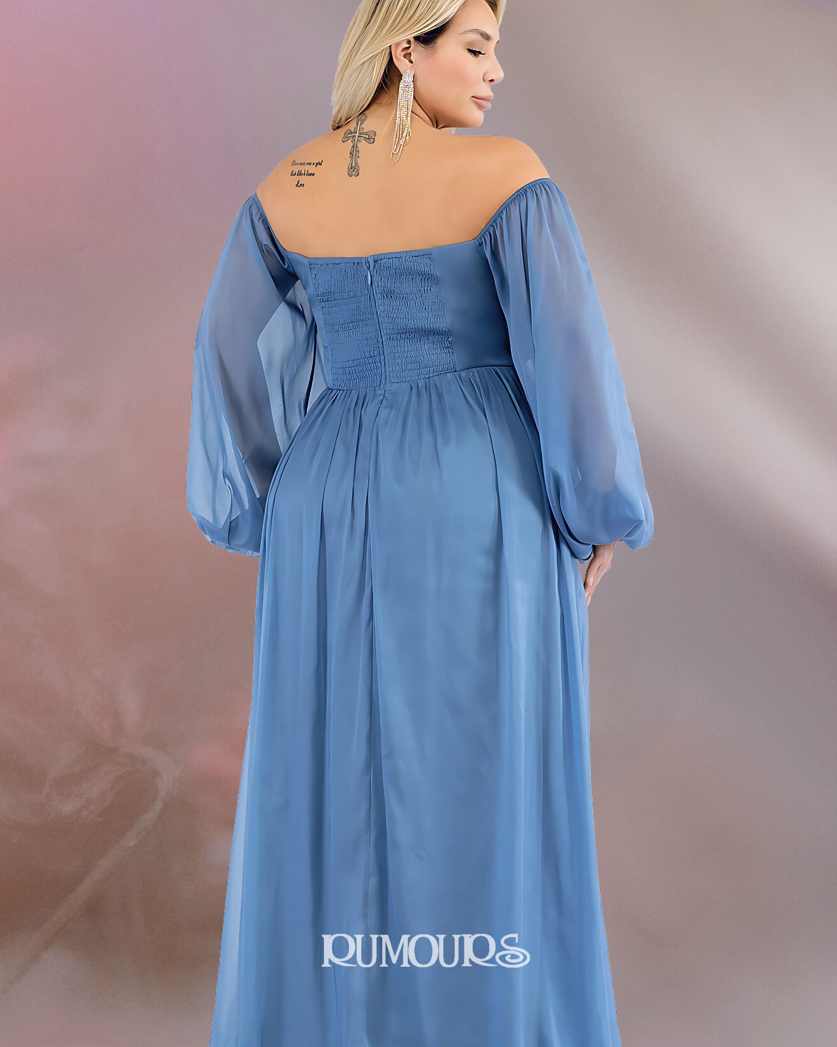 Woman in blue off-the-shoulder gown with long sleeves, standing with her back to the camera.